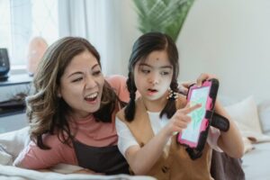 Mother and daughter enjoying quality time using a tablet together indoors.