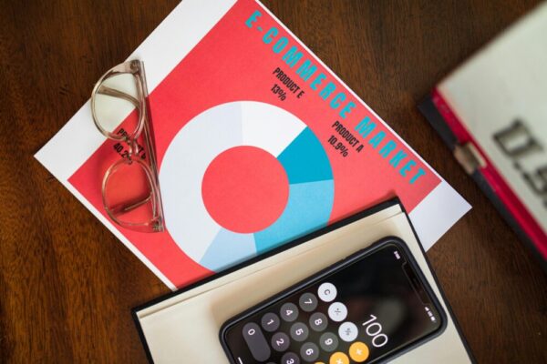 電商購物車放棄率怎麼降低?實用技巧全解析 Top view of e-commerce market analysis graph with smartphone calculator and glasses for business insights.