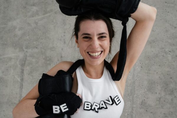 A joyful woman posing with boxing gloves and