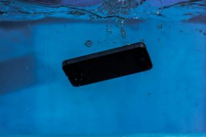 A smartphone captured underwater, illustrating themes of technology and water resistance.