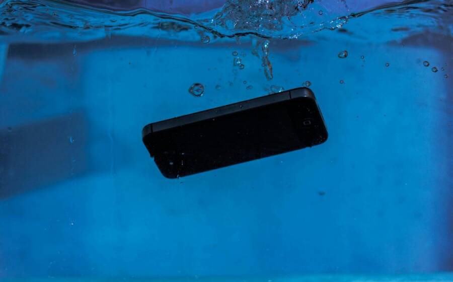 A smartphone captured underwater, illustrating themes of technology and water resistance.