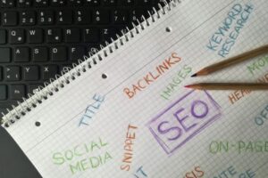 Close-up of notebook with SEO terms and keywords, highlighting digital marketing strategy.