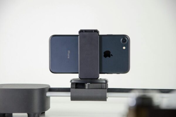 Galaxy S24 拍片指南:8K、HDR10+、超級防手震 全面上手與設定 A close-up image of a smartphone mounted on a slider, ideal for video production and cinematic capturing