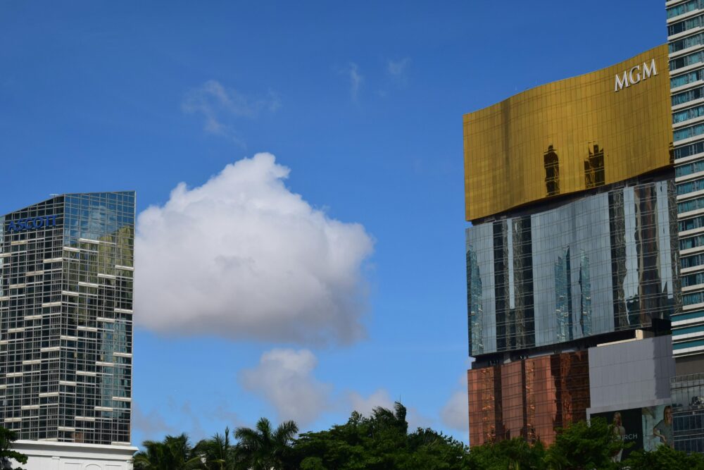 在澳門湛藍的天空下,高聳入雲的摩天大樓擁有反光的玻璃幕牆。