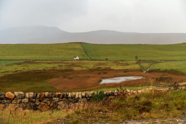 寧靜的鄉村景色，起伏的丘陵，石牆，還有一棟孤零零的房子。