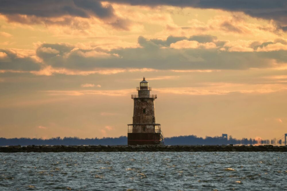 美麗的日落景色,一座古樸的燈塔突然立在平靜的大海和佈局的天空之間。