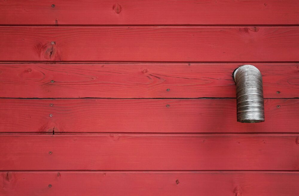 極簡主義的視角瞄準了一面紅色木牆，牆上的細線銀色金屬管，形成了暴露的對比。