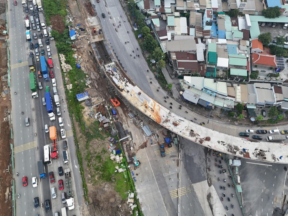 一張空拍照片，展示了越南胡志明市的高速公路建設和交通狀況。