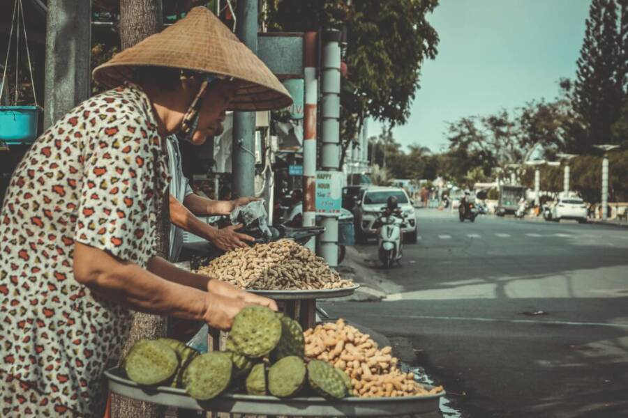 白色和紅色的花頂站在路邊的女人