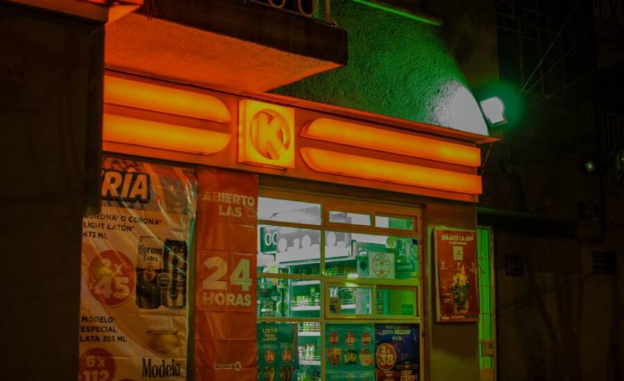 一盞燈火通明的便利商店，晚上霓虹燈閃爍，展示著鮮豔的色彩和標誌。