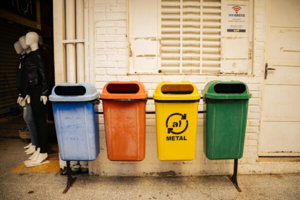 在城市環境中，四個色彩鮮豔的恢復箱靠在磚牆上，分別用於恢復不同材質的材料。