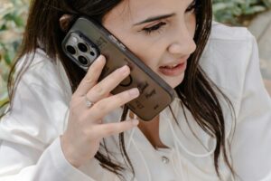 重點鏡頭：一名女子坐在戶外，將智慧型手機貼在耳邊，展示了現代通訊方式。