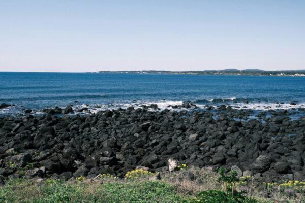 探索韓國濟州島美麗的海岸線上令人驚嘆的海岸線和藍色的海浪。