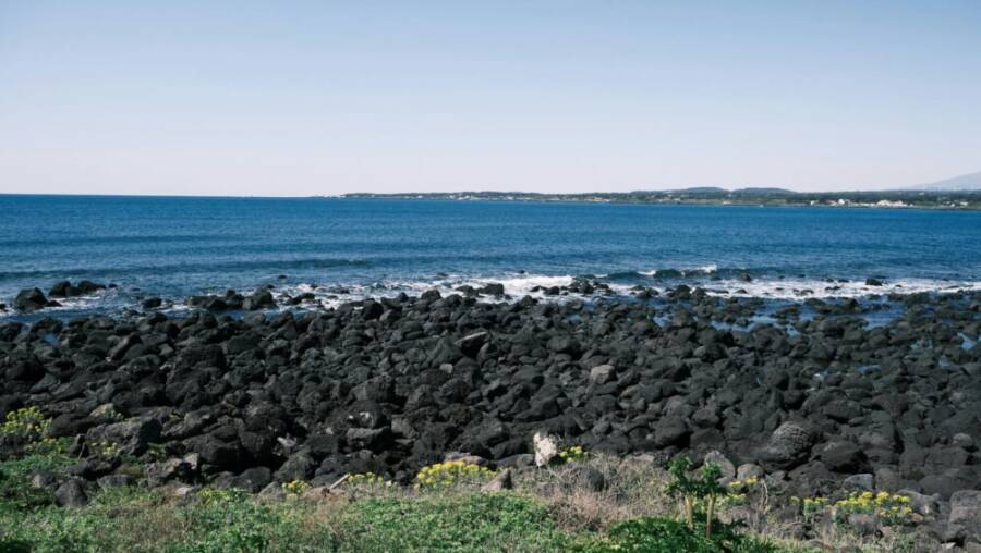 探索韓國濟州島美麗的海岸線上令人驚嘆的海岸線和藍色的海浪。