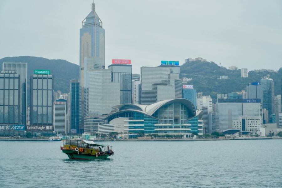 一根傳統船隻在維多利亞港的香港現代天際線前航行。