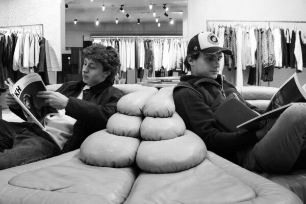 年輕男子在時裝店的沙發上放鬆地瀏覽著雜誌。