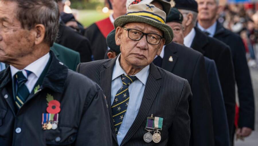 一群老年退伍老兵在戶外參加亡陣將士紀念日遊行。