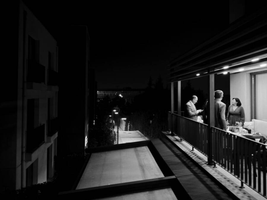 一張黑白照片，拍攝於伊斯坦堡的夜晚，人們在陽台上社交。