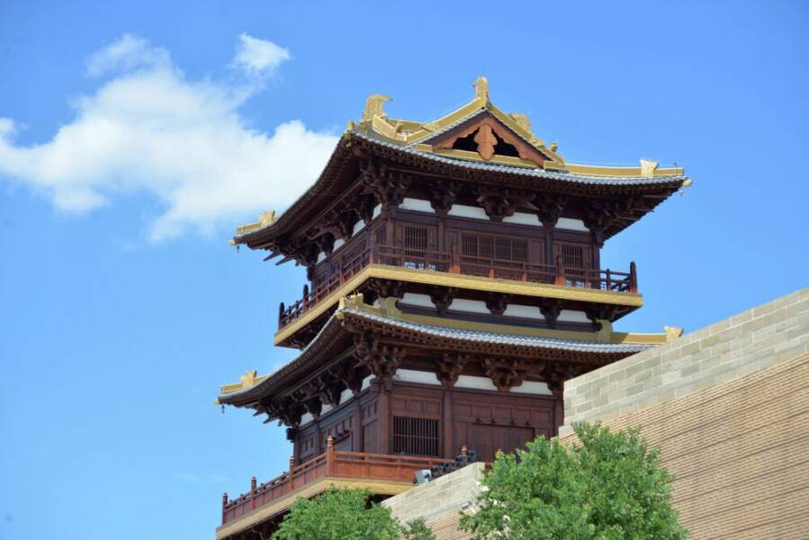 湛藍的天空下，一座裝飾華麗的寶塔立於中國傳統建築之中。非常適合文化和建築主題的拍攝。
