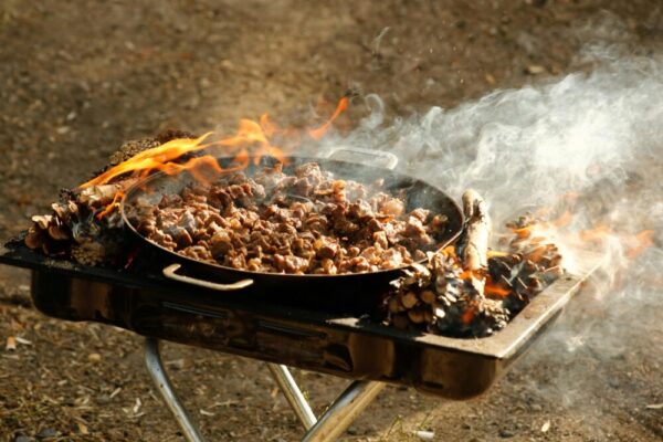 戶外燒烤架上滋滋作響的肉在南瓜和煙草中烤製的特色鏡頭。