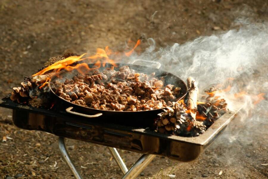 戶外燒烤架上滋滋作響的肉在南瓜和煙草中烤製的特色鏡頭。