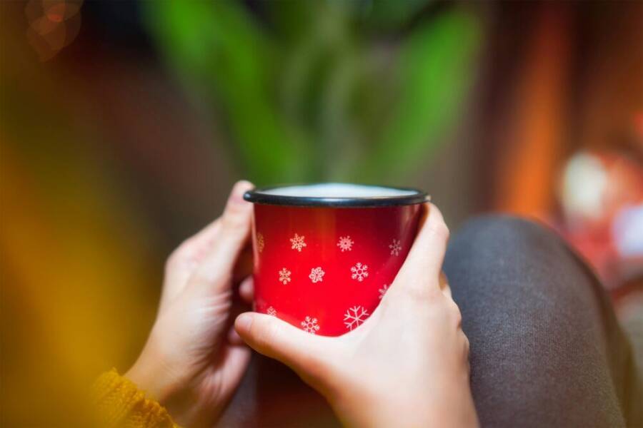 在溫馨的大廳裡，曼德手捧著一個喜氣洋洋的馬克杯。