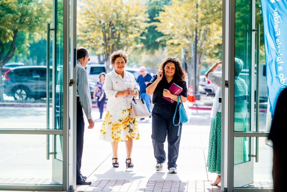 陽光明媚的日子裡，一群人微笑著走進一棟大樓。