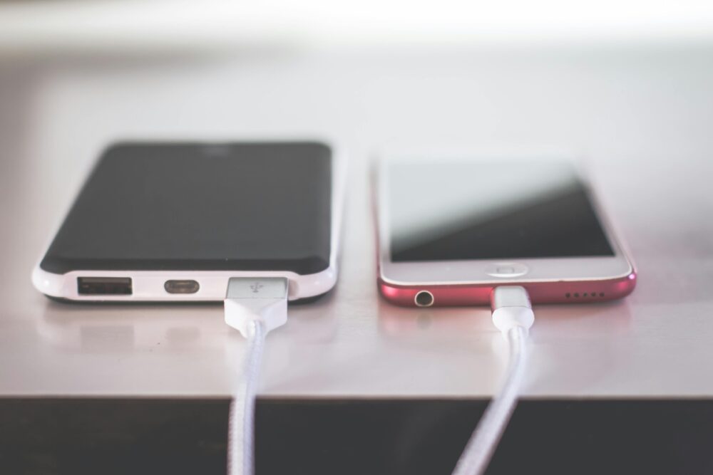Two smartphones charging side by side on a desk. Modern and technological setting.