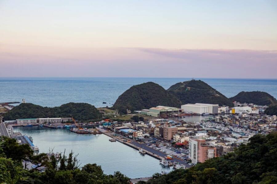 A beautiful aerial shot of Nanfangao Fishing Port at dusk in Yilan County, Taiwan, showcasing the harbor and surrounding landscape.