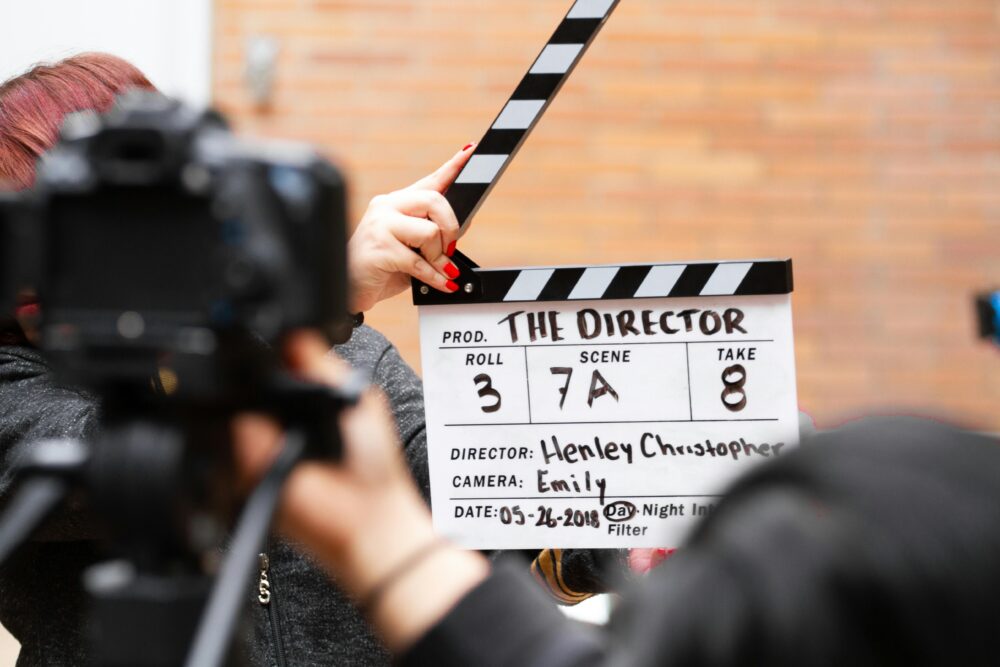 Close-up of film clapperboard in action with camera filming a take on set