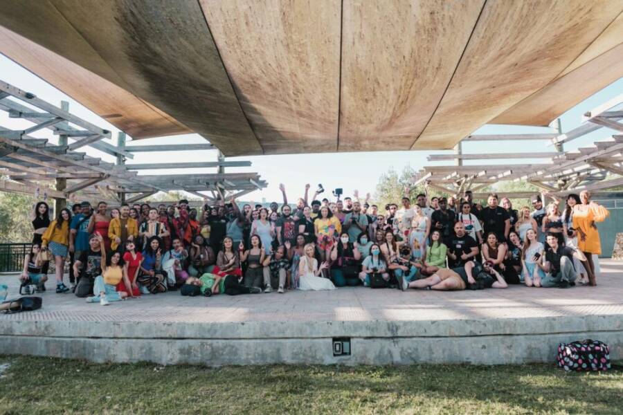 A vibrant group photo of diverse people gathering under pergola in Orlando
