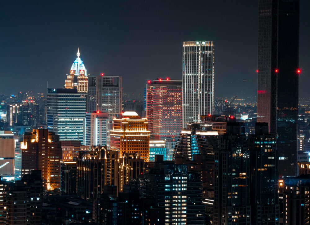 Illuminated Taipei skyline featuring skyscrapers and vibrant city lights at night.