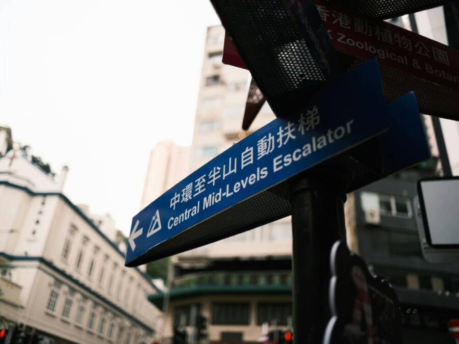 Urban street sign pointing to Central Mid-Levels Escalator in Hong Kong