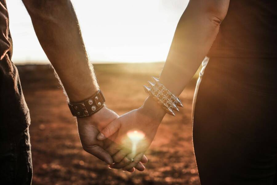 Close-up of a couple holding hands at sunset