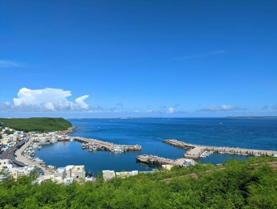 A breathtaking aerial view of Magong harbor in Taiwan, showcasing docks, boats, and blue skies.