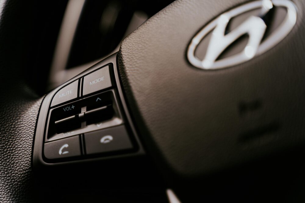 Detailed view of a car steering wheel with audio control buttons, focused on functionality.