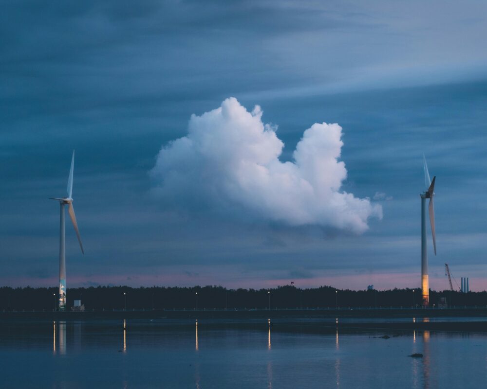 Wind turbines on calm water at twilight in Taichung, reflecting the sky