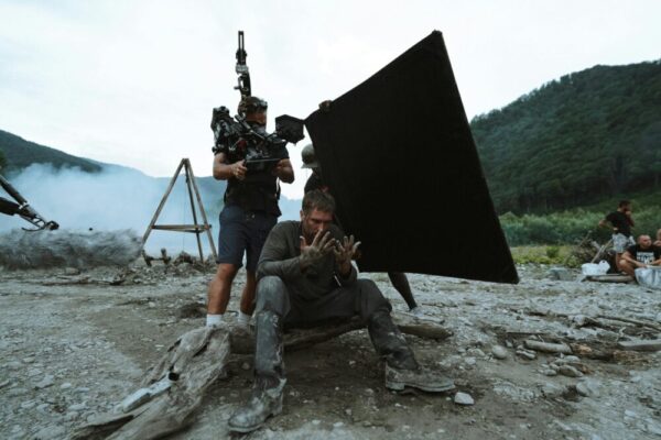 A breathtaking real-life film location in Taiwan, such as a misty mountain valley at dawn with golden natural light filtering through ancient trees