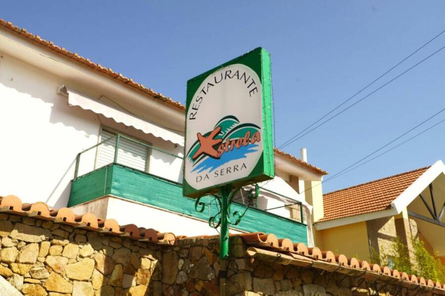 Signage of Restaurante Estrela da Serra on a sunny day in Lisbon, Portugal.