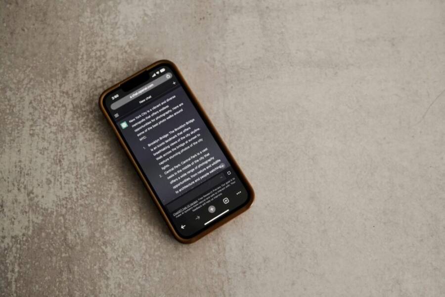 A smartphone displaying a messaging app screen, placed on a textured surface.
