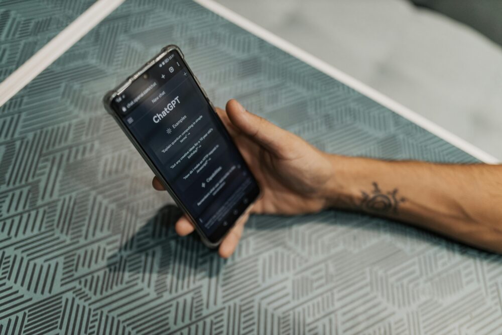 Close-up of a smartphone in hand with ChatGPT on the screen, symbolizing AI technology