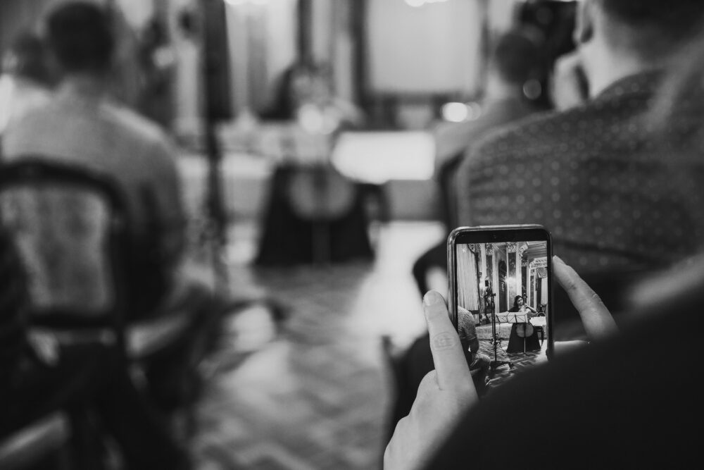 Black and white photo of a classical music performance in Hanover, Germany, as seen through a smartphone