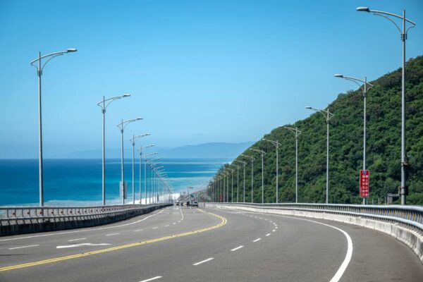 Explore the stunning coastal road in Taidong, Taiwan with lush greenery and ocean views.