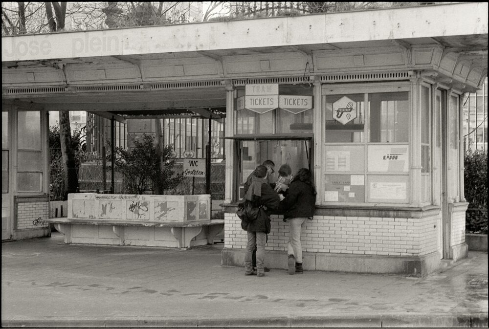 Vintage tram ticket booth with people buying tickets in black and white