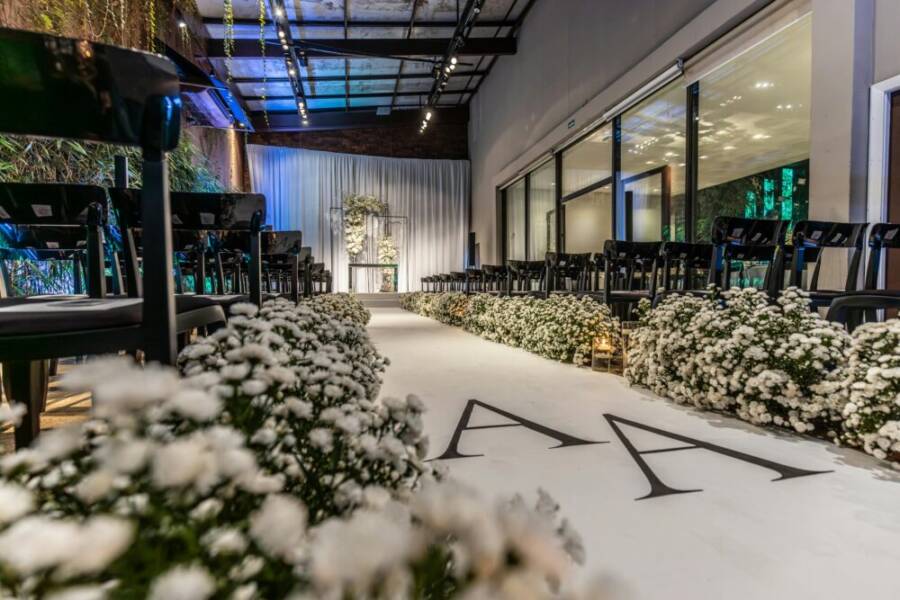 Beautifully decorated indoor wedding venue with white florals and elegant seating arrangement.