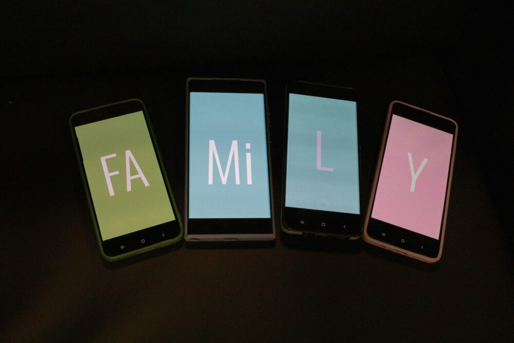 Four smartphones with colored screens spell