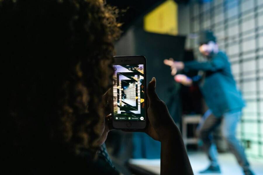 A person taking a photo of a live performance using a smartphone