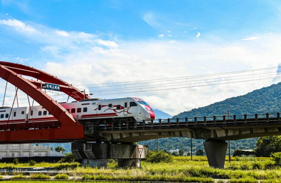High-speed train on a red bridge in scenic Taiwan, near Hualien