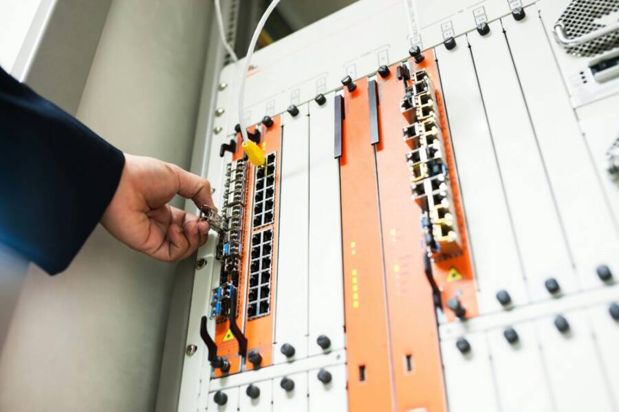 Close-up of a hand adjusting network equipment in a data center