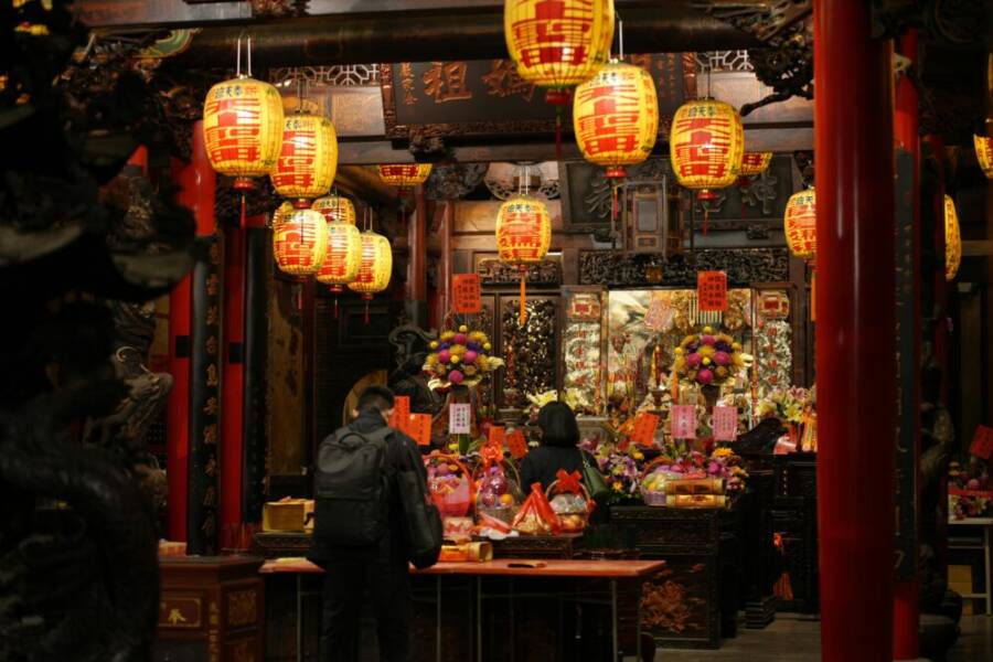 Traditional Taiwanese temple interior decorated with lanterns and offerings, rich in cultural elements.